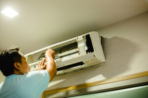 Air conditioning technician is cleaning the air conditioner in the bedroom or office room.